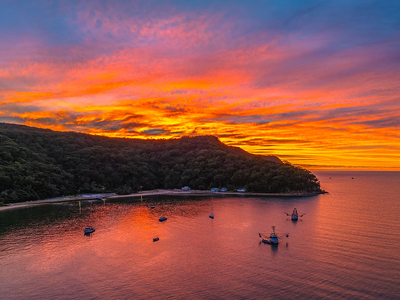 Sunrise over the bay with boats and cloud covered sky