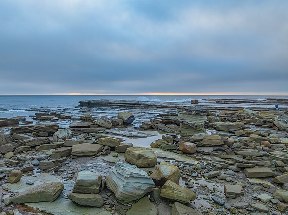 Sunrise seascape and rocky Inlet with thick fog cloud over the o