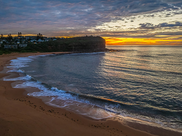 Sunrise Seascape  with Calm Seas and a Cloud Covered Sky