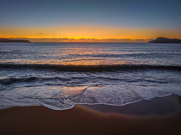 Aerial sunrise seascape with clear skies and low cloud bank