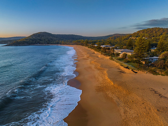 Aerial sunrise seascape with clear skies and low cloud bank