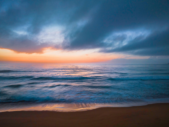 Summer sunrise at the seaside with clouds and haze