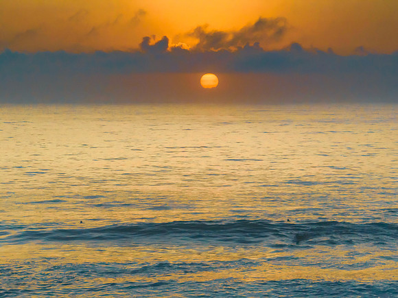 Summer sunrise at the seaside with clouds and haze