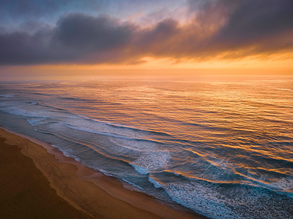 Summer sunrise at the seaside with clouds and haze
