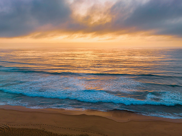 Summer sunrise at the seaside with clouds and haze
