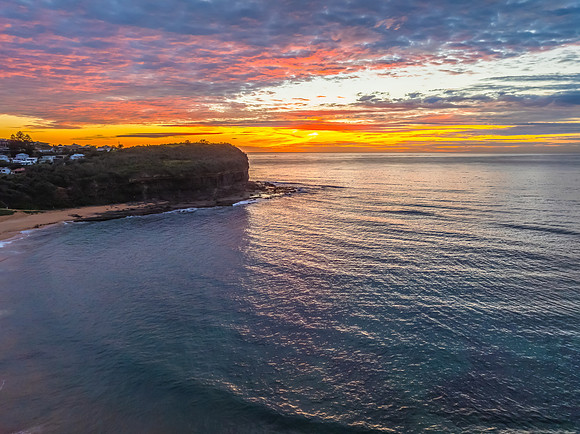 Sunrise Seascape  with Calm Seas and a Cloud Covered Sky