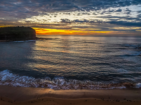 Sunrise Seascape  with Calm Seas and a Cloud Covered Sky