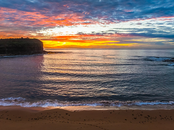 Sunrise Seascape  with Calm Seas and a Cloud Covered Sky