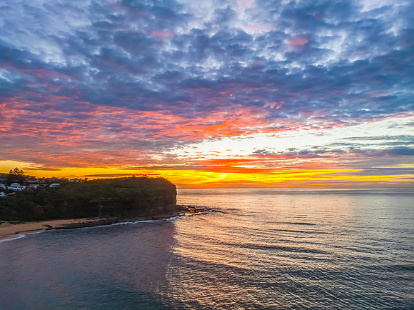 Sunrise Seascape  with Calm Seas and a Cloud Covered Sky