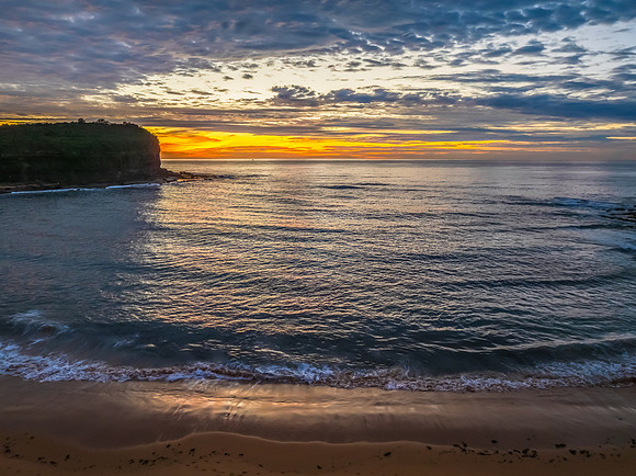 Sunrise Seascape  with Calm Seas and a Cloud Covered Sky
