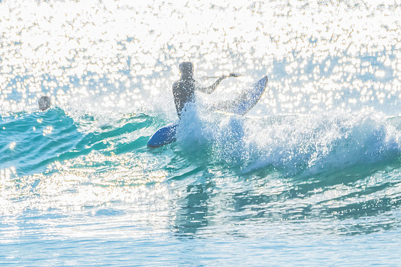 Light Sparkling on the Ocean with a Ski Paddler