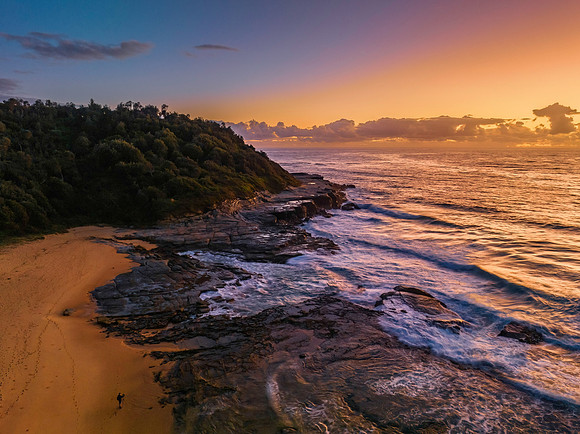 Summer sunrise at the seaside with clouds and rocks