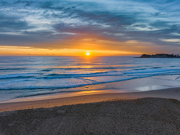 High cloud and sun rising on the horizon at the seaside