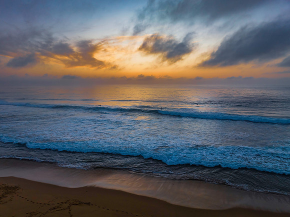 Summer sunrise at the seaside with clouds and haze