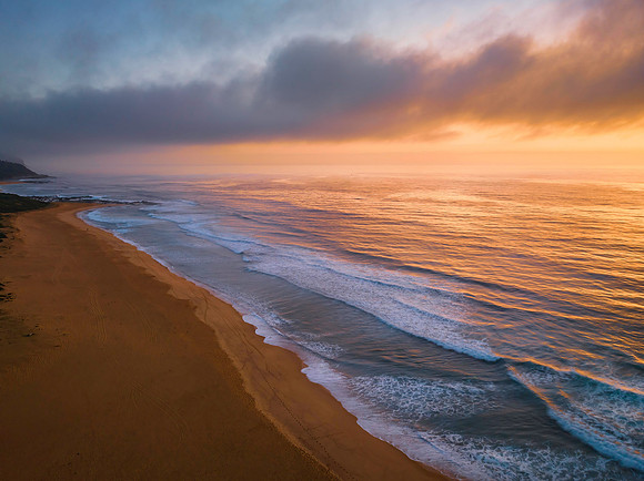 Summer sunrise at the seaside with clouds and haze