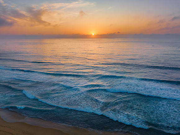 Summer sunrise at the seaside with clouds and haze