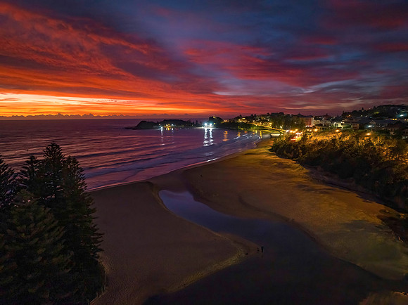 High cloud sunrise at the seaside with street lights and reflect