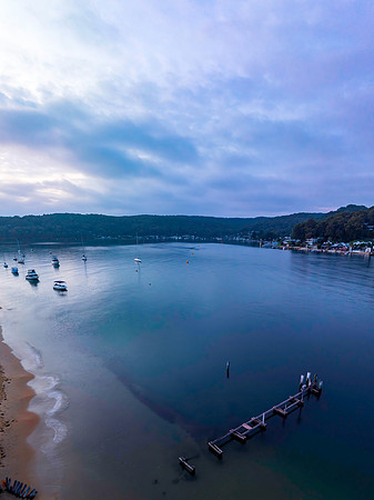 A subtle sunrise waterscape with boats and clouds