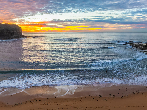 Sunrise Seascape  with Calm Seas and a Cloud Covered Sky