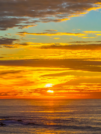 Sunrise Seascape  with Calm Seas and a Cloud Covered Sky