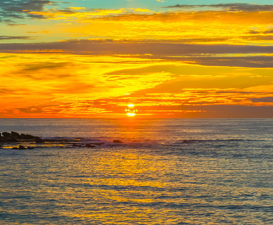 Sunrise Seascape  with Calm Seas and a Cloud Covered Sky