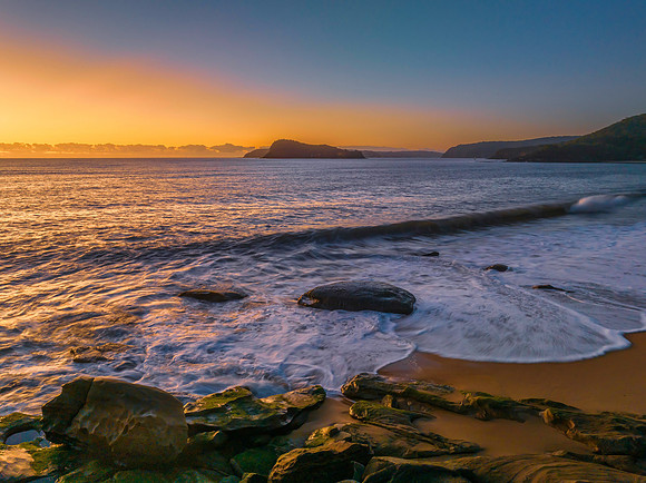 Aerial sunrise seascape with clear skies and low cloud bank