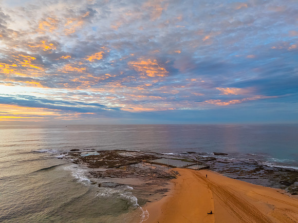 Sunrise Seascape  with Calm Seas and a Cloud Covered Sky