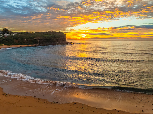 Sunrise Seascape  with Calm Seas and a Cloud Covered Sky