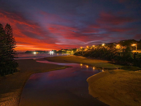 High cloud sunrise at the seaside with street lights and reflect