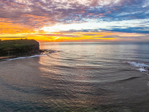 Sunrise Seascape  with Calm Seas and a Cloud Covered Sky