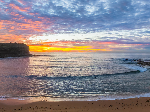 Sunrise Seascape  with Calm Seas and a Cloud Covered Sky