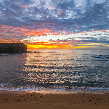 Sunrise Seascape  with Calm Seas and a Cloud Covered Sky
