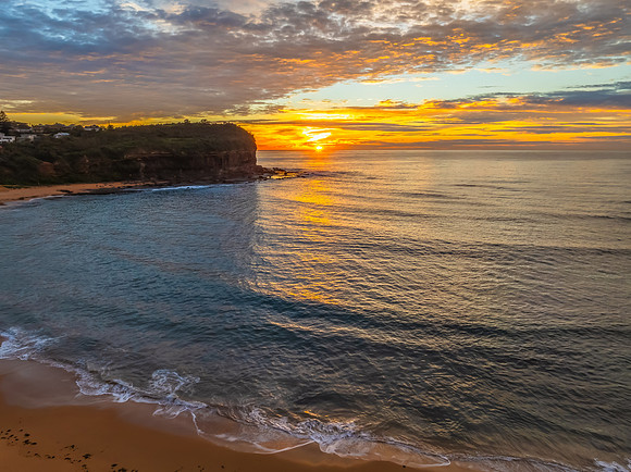 Sunrise Seascape  with Calm Seas and a Cloud Covered Sky