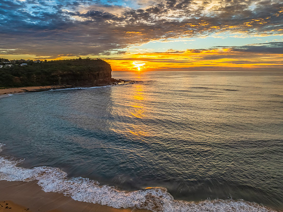 Sunrise Seascape  with Calm Seas and a Cloud Covered Sky