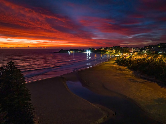 High cloud sunrise at the seaside with street lights and reflect