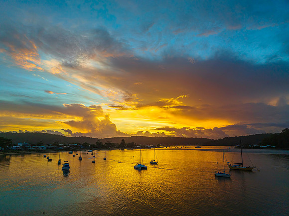 Aerial sunrise waterscape with boats, colour and clouds