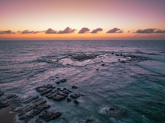 Aerial sunrise seascape with  high tide and rock platform