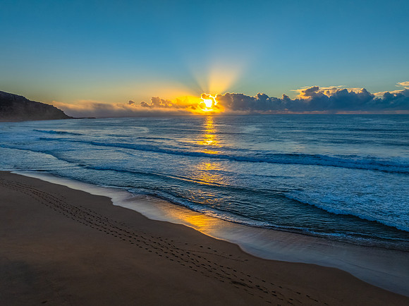 Sunrise over the sea with a low cloud bank and fog