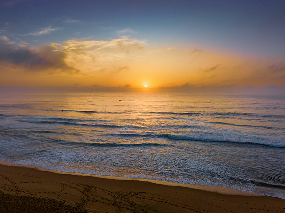 Summer sunrise at the seaside with clouds and haze