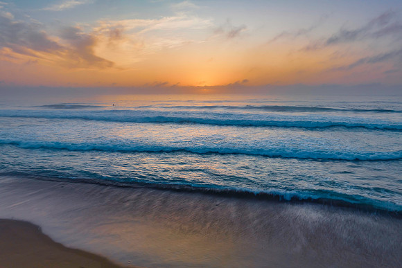 Summer sunrise at the seaside with clouds and haze