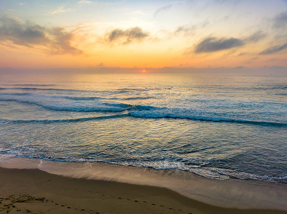 Summer sunrise at the seaside with clouds and haze