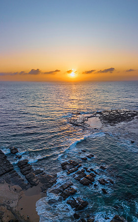 Aerial sunrise seascape with the sun, high tide and rock platfor