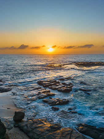 Aerial sunrise seascape with the sun, high tide and rock platfor
