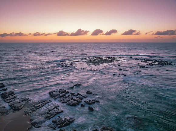 Aerial sunrise seascape with  high tide and rock platform