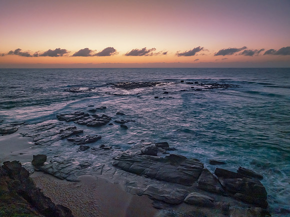 Aerial sunrise seascape with  high tide and rock platform