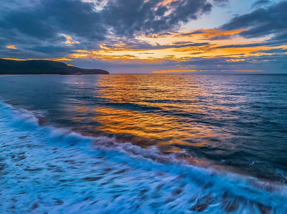 Sunrise seascape with clouds and gentle surf
