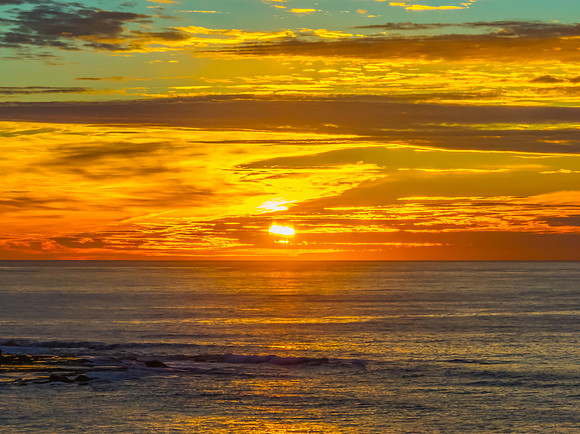 Sunrise Seascape  with Calm Seas and a Cloud Covered Sky