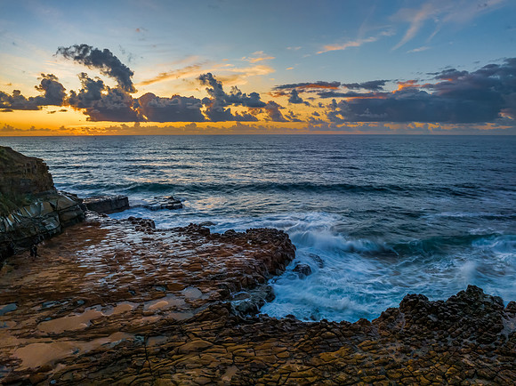 Sunrise and clouds over the ocean and rock platform