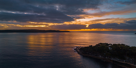 Aerial sunrise seascape with calm seas and a mix of high and low