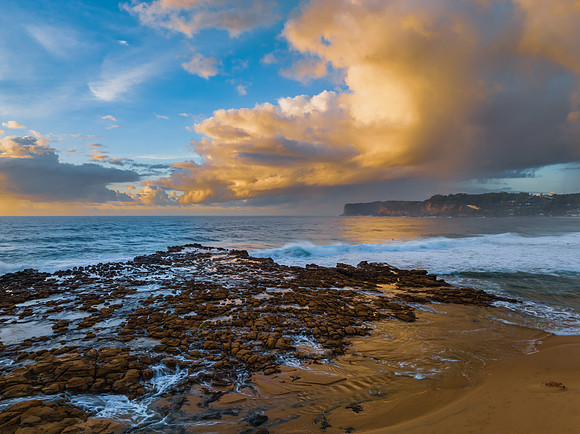 Sunrise and clouds over the ocean and rock platform